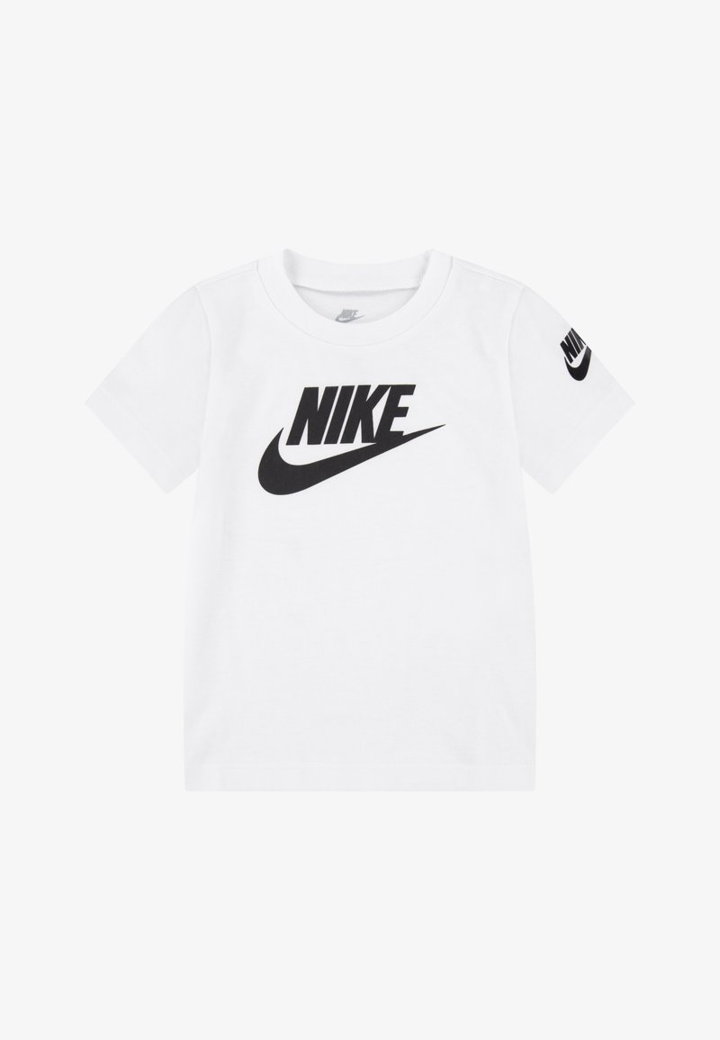 Balta medvilnės marškinėliai su dideliu juodu "NIKE" logotipu priekyje ir mažesniu logotipu kairiajame rankovėje. Trumpi rankoviai ir apvalus kaklas.