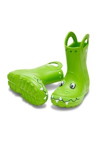 Botas de lluvia verdes de goma con asa, que presentan un diseño de cocodrilo, ojos grandes, dientes afilados, suelas texturizadas y un acabado suave.