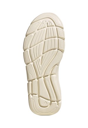 Suela de sandalia con banda de goma beige que presenta patrones geométricos y ranuras para tracción y flexibilidad, mostrada desde abajo.