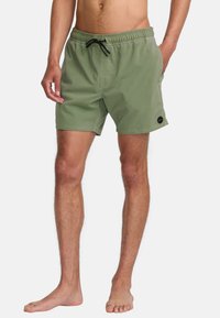 Shorts de bain pour homme verts avec une taille élastique, cordon de serrage et poches latérales. Fabriqués en tissu lisse avec un patch logo.