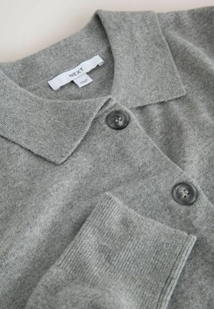 Harmaa neulottu cardigan, jossa on litteä kaulus, kaksi tummaa nappia, ribbireunat sekä pehmeä rakenne. Tarkoitus näyttää tuotemerkin nimen "NEXT".