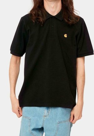 Camiseta polo negra con un cuello de dos botones, mangas cortas y un pequeño logo amarillo en el pecho. Fabricada en algodón, presenta un corte clásico.