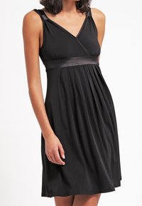Mustapuku ilman hihoja, jossa on V-kaula-aukko ja laskostettu hame, varustettuna satiini vyötäröllä ja sileällä kankaan tekstuurilla.
