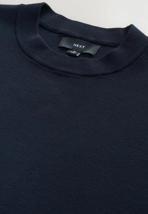 Tengerészkék pulóver bordás, kerek nyakkivágással, puha texturált anyagból készült. A címkén a "NEXT" felirat olvasható, M-es méret. Egyszerű, mintázat nélküli dizájn.