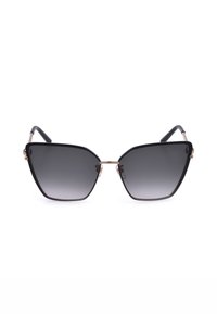 Lunettes de soleil œil de chat noires avec verres dégradés foncés et fine monture en métal doré sur fond blanc.
