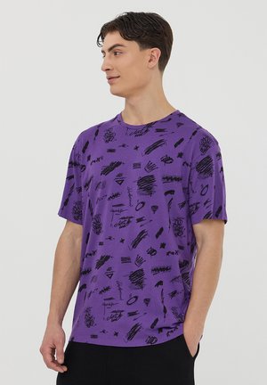 T-shirt viola a maniche corte con un motivo astratto nero di linee e forme, realizzato in morbido cotone.