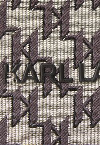 Purple and cream woven fabric featuring a geometric zigzag pattern, with black embossed "KARL LAGERFELD" branding prominently displayed.