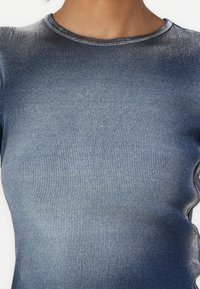 Blue ribbed fabric with a soft texture, featuring a rounded neckline. The design has subtle shading, transitioning from dark to light blue.