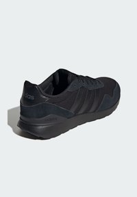 Czarny but sportowy z siateczkową i zamszową cholewką, wyposażony w trzy tonacyjne paski, zaokrąglony nosek i amortyzowaną podeszwę.