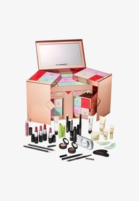 Caja rectangular de oro rosa con un espejo, que contiene compartimentos numerados de colores, rodeada de varios productos de maquillaje de MAC.