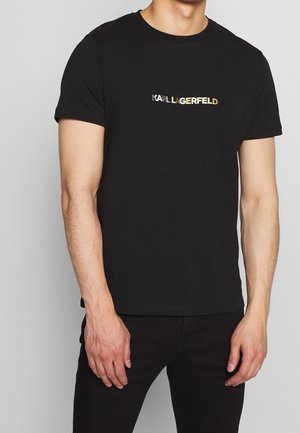 Black cotton T-shirt featuring a round neckline and short sleeves, adorned with a metallic gold "KARL LAGERFELD" logo across the chest.
