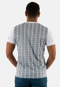 Camiseta de manga corta con un patrón a rayas en gris y blanco, que presenta diseños de logotipos circulares repetidos en la parte posterior. Tejido de mezcla de algodón.