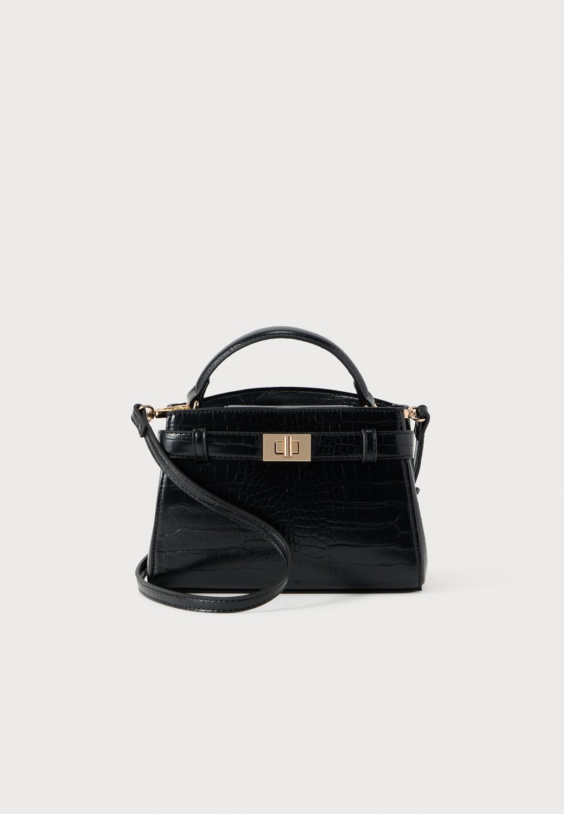 Petit sac à main noir avec finition texturée, poignée unique sur le dessus, bandoulière détachable et fermoir à twist rectangulaire doré.