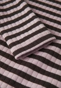 Brun och rosa randig tyg, ribbad textur, med en vikt ärm som visar sömnadsdetaljer och betonar det horisontella randmönstret.