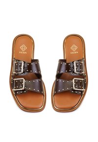 Bruine leren slipper sandalen met twee brede banden, zilveren gespaccenten, gouden studdetails en een bruine gevoerde binnenzool.