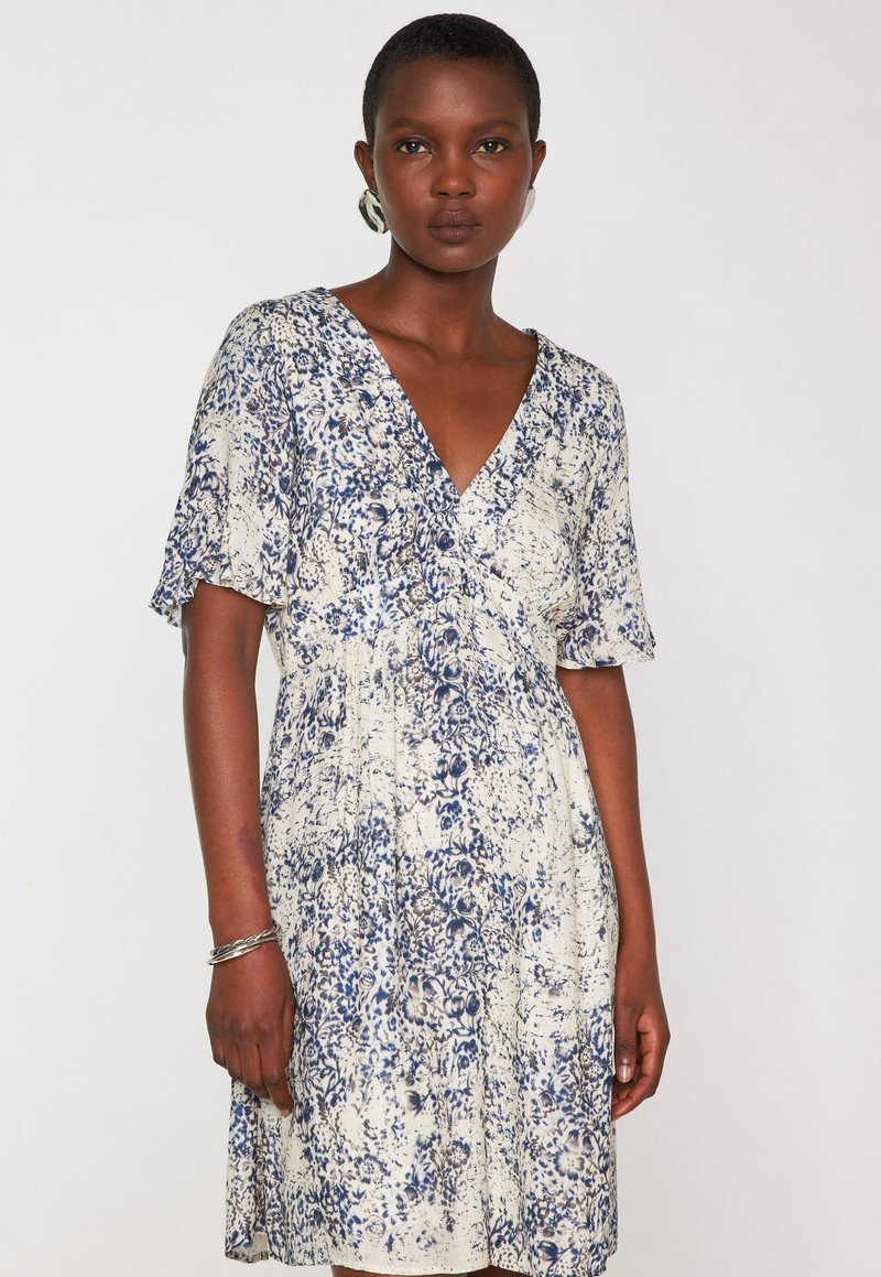 Abito a maniche corte in crema con motivo floreale blu, scollatura a V, vita arricciata e tessuto morbido e leggero.