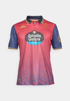 Rød og marineblå fodboldtrøje med krave, der har et gradientdesign, logoer og et stort sort sponsorlogo på fronten.