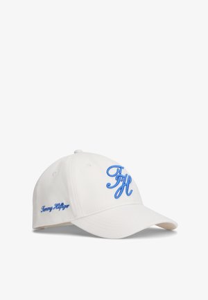 Casquette de baseball blanche avec les initiales "TH" brodées en bleu sur le devant et "Tommy Hilfiger" sur le côté, visière courbée et arrière ajustable.