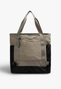 Bolsa tote en beige y negro, hecha de un tejido duradero. Cuenta con dos asas para el hombro, un bolsillo frontal con cremallera y un amplio compartimento principal.