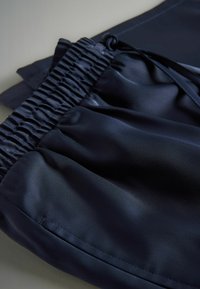 Jūras kara flotes samta šorti ar savilkta elastīgā josta, ar gludu, spīguļojošu tekstūru un taisno apakšmalu, piemēroti ikdienas valkāšanai.