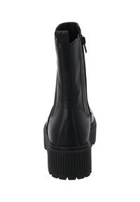 Mustat nahkaiset nilkkurit, joissa on teksturoitu kumipohja, takaketju ja kevytrakenteisuus. Ominaisuuksina minimalistinen tyyli ja suora siluetti.