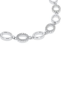 Armband i silverfärg med växlande släta och ädelstensprydda ovala länkar, som visar upp polerat metall och glittriga detaljer.