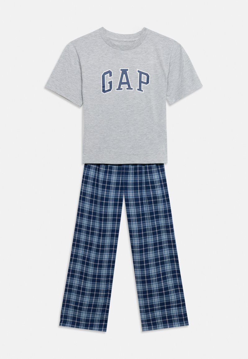 T-shirt gris clair à manches courtes avec le texte GAP, associé à un pantalon de pyjama à carreaux bleu et blanc, posé à plat sur un fond blanc.