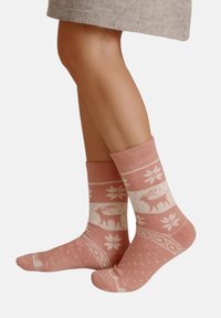 Knee-high, pink socks featuring white winter-themed patterns, including deer and snowflakes, with a ribbed cuff and soft texture.