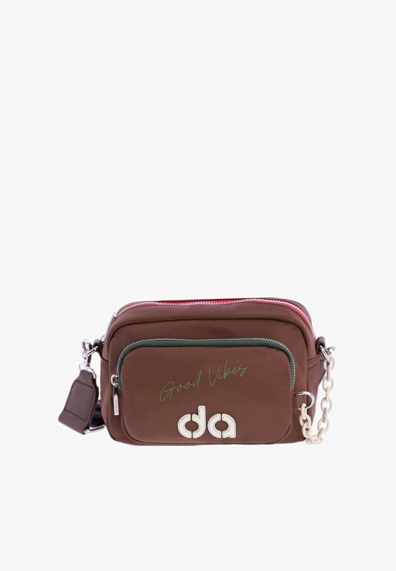 Bolso bandolera marrón hecho de material sintético. Cuenta con un bolsillo delantero con cremallera, herrajes plateados y el texto "Good Vibes" en verde.