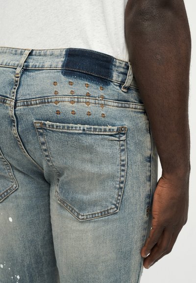 Ανοιχτό μπλε τζιν παντελόνι με ξεθωριασμένο ξεβάμμα, με σκουρό μπλε ζώνη μέσης, διακοσμητικές ραφές στις πίσω τσέπες και σχέδιο στενής εφαρμογής.