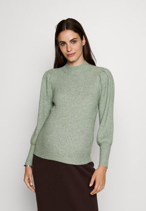 Light green ribbed knit sweater with a high neck and puffed sleeves, paired with a dark brown ribbed skirt. Smooth texture and fitted design.