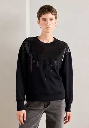 Schwarzer Sweatshirt mit einem Pailletten-Gradienten-Design auf der oberen Vorderseite. Gefertigt aus einem weichen Stoff mit gerippten Bündchen und Saum.
