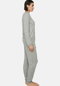 Ensemble de vêtements d'intérieur gris à côtes composé d'un haut à manches longues et d'un pantalon fuselé, fabriqué dans un tissu doux avec une coupe détendue. Pas de motifs visibles.