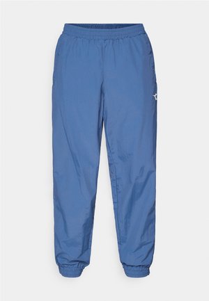 Pantalon de jogging léger et bleu avec une taille élastique et des bords élastiques. Comprend des poches latérales et un petit logo sur la jambe gauche.
