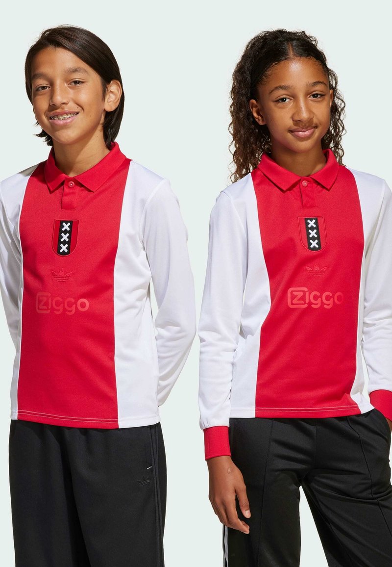 Červené a biele dlhé rukávy polo tričká s golierom, s čiernym emblémom s bielymi akcentmi a čierne športové nohavice.