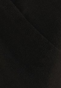 Černá texturovaná tkanina s měkkým, sametovým povrchem; má hladký povrch a jemnou variaci v odstínech po celé ploše materiálu.