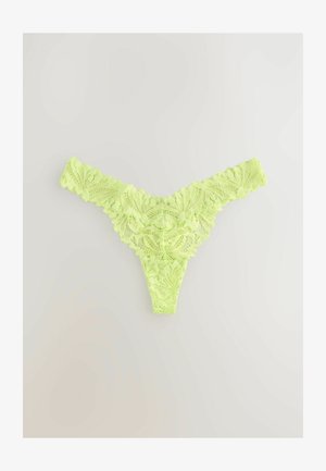 String en dentelle vert lime avec un motif floral. Les bords décoratifs en forme de vague et la texture transparente renforcent son apparence délicate.