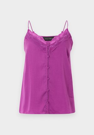 Vijolična brezrokavnik s čipkasto obrobo ob izrezu in gumbi, prekritimi z blago, po sredini spredaj.