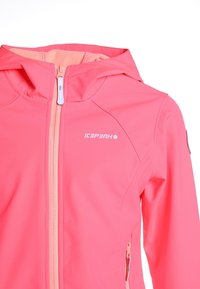 Chaqueta softshell rosa brillante con capucha, cremallera frontal completa, bolsillos laterales con cremallera y logo "ICEPEAK" en el pecho.