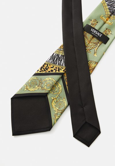 Zijde stropdas met een zwarte achterkant en sierlijke ontwerpen in groen, goud en dierenprints, waaronder leopards, met een zichtbaar "Versace Made in Italy" label.