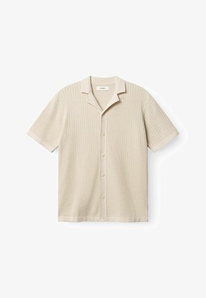 Smėlio spalvos trumpomis rankovėmis marškiniai su reljefiniu, ribsčių raštu, apykakle ir penkiais mygtukais priekyje. Lygus audinio paviršius.