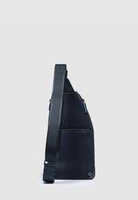 Borsa a tracolla blu navy con tessuto strutturato, forma triangolare, scomparto principale con cerniera e tracolla regolabile con dettagli in accento blu.