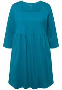 Tyrkysové šaty s dlouhým rukávem a čtvercovým výstřihem, nařaseným pasem a měkkou bavlněnou tkaninou. Lehce rozšířený tvar, hladká textura.