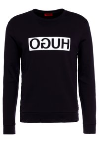 Felpa nera con un logo rettangolare bianco con la scritta "HUGO" in grassetto e maiuscolo. Collo a giroclassico e maniche lunghe.
