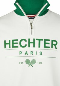 Witte zip-up sweater met een groene kraag, met groene tekst "HECHTER PARIS" en een tennisafbeelding. Gemaakt van een zachte katoenmix.