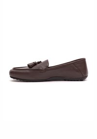 Mocassino in pelle marrone con punta tonda, nappine decorative sulla parte anteriore e una suola piatta in gomma con piccoli punti di trazione.