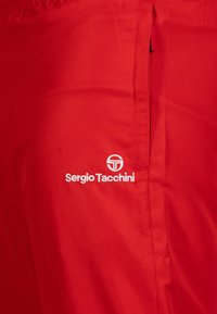 Rode tennis shorts van stof met een gestructureerd oppervlak, een elastische tailleband en een wit geborduurde "Sergio Tacchini" logo.
