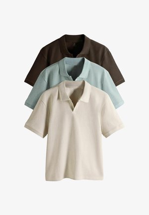 Három rövid ujjú galléros póló bézs, világoskék és sötétbarna színekben, egymásra halmozva, a gallérok és a texturált anyag látható.