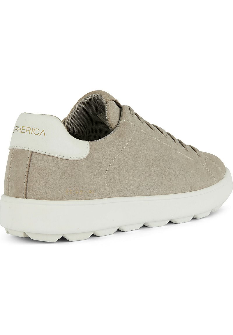 Beżowe zamszowe trampki z białą gumową podeszwą, charakteryzujące się wyściełanym językiem, detalem logo na pięcie oraz teksturowaną siatkową podszewką.