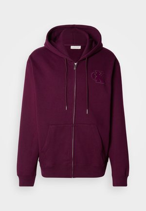 Hanorac zip-up bordo din material moale, cu buzunar tip kangaroo și logo brodat pe piept. Dispune de șnururi de strângere și manșete ribbate.